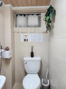 a white bathroom with a toilet and a sink at Green Home Stay in Seoul