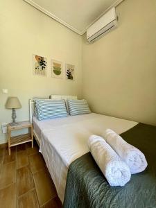 een slaapkamer met een groot bed en handdoeken bij Lily's studio in Vathí
