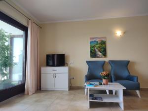 sala de estar con 2 sillas azules y mesa en Oliva Apartments Lozica, en Dubrovnik