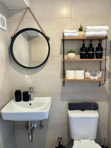 a bathroom with a sink and a mirror and a toilet at Lily's studio in Vathí +33 photos