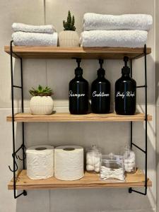 un estante con toallas y botellas negras. en Lily's studio en Vathí