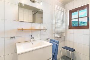 a white bathroom with a sink and a window at Ferienhaus Charlotte in Zell am Harmersbach +19 photos
