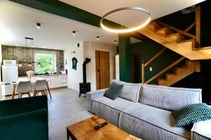 a living room with a couch and a kitchen at Apartamenty Karkonoska Dolina in Staniszów