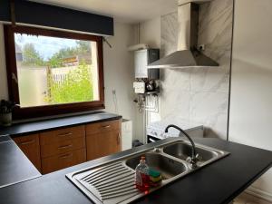 cocina con fregadero y ventana en Camping De Collignon, en Cherbourg-en-Cotentin