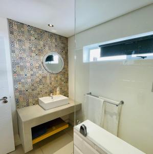 a bathroom with a sink and a mirror at Hill Sea-View Apartment in Plettenberg Bay +32 photos