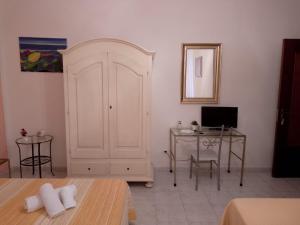 een kamer met een witte deur en een bureau met een computer bij Scilla A Vinedda in Scilla