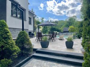 a patio with a table and chairs and an umbrella at VILLA-Harmony in Ustroń