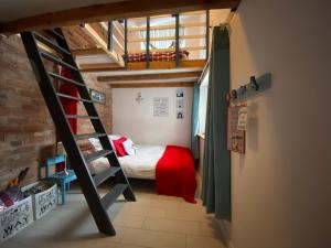 um pequeno quarto com um beliche e uma escada em Domek całoroczny blisko lasu i morza na urokliwej działce 4300 m2 em Orlinki