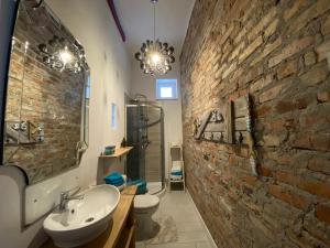 baño con lavabo y pared de piedra en Domek całoroczny blisko lasu i morza na urokliwej działce 4300 m2, en Orlinki