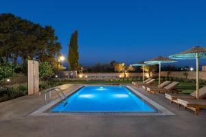 uma piscina com dois salões e um pátio em Villa Ethria Rhodes em Afantou