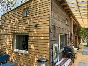 una casa in legno con finestra e griglia di Domek całoroczny blisko lasu i morza na urokliwej działce 4300 m2 a Orlinki