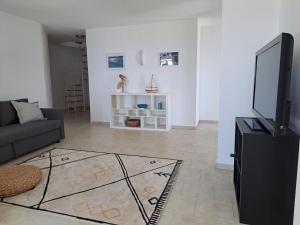 a living room with a couch and a flat screen tv at Villa Emilios in Lakhanádha