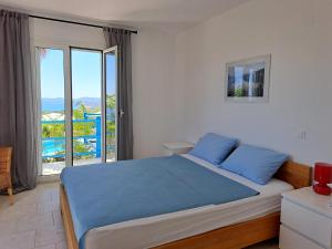 a bedroom with a blue bed and a balcony at Villa Emilios in Lakhanádha +40 photos