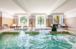 an indoor pool with a fountain in a hotel room at VIVA Cala Mesquida Suites & Spa Adults Only 16 in Cala Mesquida