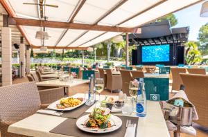 a restaurant with tables and chairs with plates of food at VIVA Cala Mesquida Suites & Spa Adults Only 16 in Cala Mesquida
