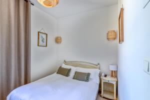 a bedroom with a bed with white sheets and pillows at La Garoupe-Gardiole in Antibes