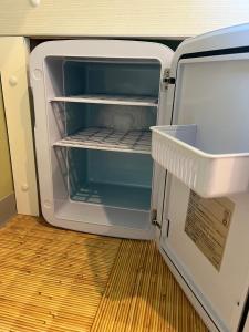 an empty refrigerator with its door open in a room at DainHostel2 in Tokyo