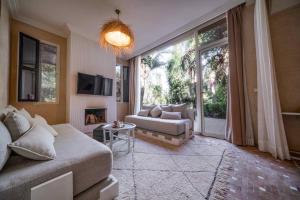 uma sala de estar com um sofá e uma lareira em Riad Jawad & Spa em Marrakech