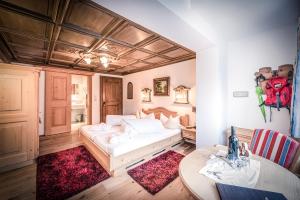 een slaapkamer met een bed, een tafel en een bureau bij HAUSEREI am Lech in Steeg