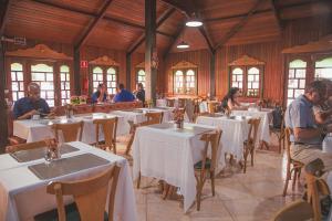 a restaurant with white tables and people sitting at them at Italian Palace Hotel in Sinop