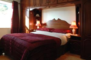 um quarto com uma grande cama de madeira e 2 candeeiros em Caldra B&B em Buncrana