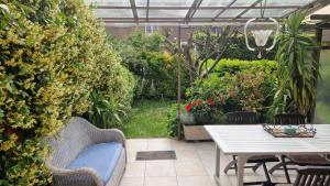eine Terrasse mit einem Tisch, Stühlen und Pflanzen in der Unterkunft Stanza in villa con giardino in Mailand