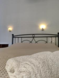 een wit bed met twee lichten erop bij Sidra Hotel in Hydra