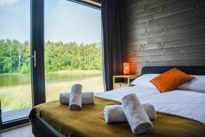a bedroom with a bed and a large window at Ruciane Park - Mazury resort & spa in Ruciane-Nida