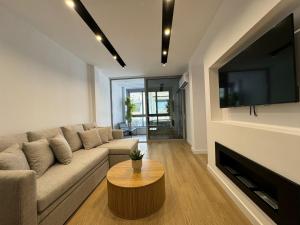 a living room with a couch and a flat screen tv at PortStay - Complex N71 in Piraeus
