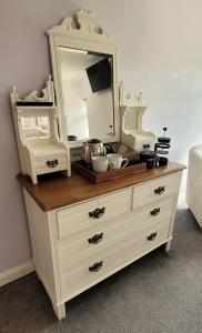 een dressoir met een spiegel erop bij Kingsley Cottage B & B in Beaworthy