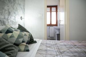 a bedroom with a bed with green pillows and a window at Magenta Collection Terrione 19 in Rome