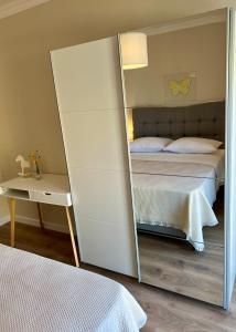 1 dormitorio con espejo junto a la cama en Apartments Dalmatino, en Vodice