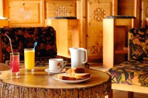 een salontafel met een bord brood en twee drankjes bij VTF Les Esquirousses in Arvieux