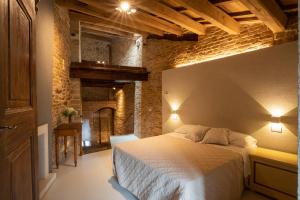 1 dormitorio con cama y pared de ladrillo en The Monastery - Unique Vacation Home, en Monteprandone