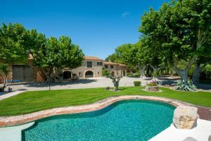 a swimming pool in a yard with trees and a house at Gîte Cerise - Maison climatisée avec piscine in Istres