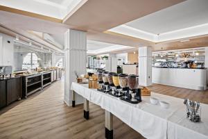 ein Restaurant mit weißen Tischen mit Essen darauf in der Unterkunft Family Resort del Mar in Pula