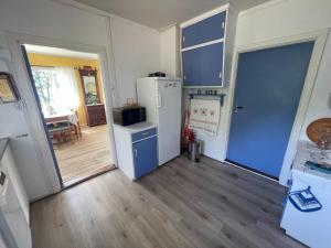een lege keuken met een koelkast en een deur bij Furuly by Norgesbooking - cabin 20 meters from the beach in Hyggen