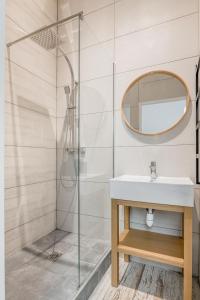 La salle de bains est pourvue d'un lavabo et d'une douche. dans l'établissement COZY HAVEN Appart. industriel neuf proximité hôpital Bellevue, à Saint-Étienne