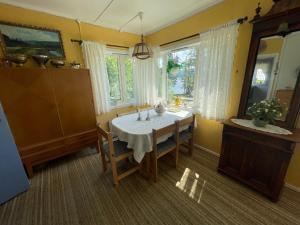 een eetkamer met een tafel en een aantal ramen bij Furuly by Norgesbooking - cabin 20 meters from the beach in Hyggen