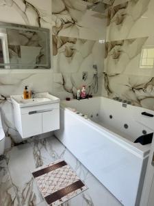 uma casa de banho com uma banheira branca e um lavatório. em Qyteza Guest House & Camping em Shkodër