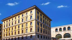 um grande edifício amarelo em frente a dois edifícios em Gioberti Art Hotel em Roma