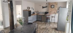 a kitchen with a table and a refrigerator at LE GITE in Bracieux