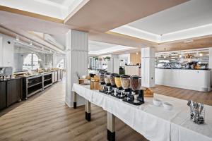 Residence Superior Del Mar في بولا: مطعم بطاولات بيضاء عليها طعام
