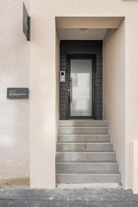 - l'entrée d'un bâtiment avec une porte et des escaliers dans l'établissement COZY HAVEN Appart. industriel neuf proximité hôpital Bellevue, à Saint-Étienne