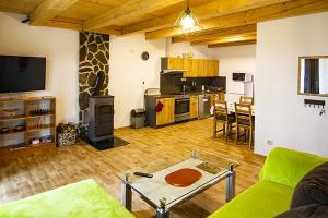 a living room with a couch and a table and a kitchen at Chaty Dvořiště in Lomnice nad Lužnicí