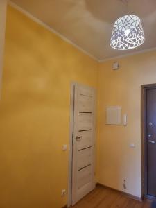 Habitación con puerta y pared amarilla en Giedres apartaments-Alkava, en Kaunas