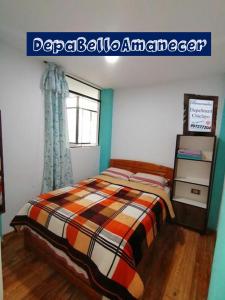 a bedroom with a bed with a comforter and a window at Departamento Smart- Chiclayo B2 in Chiclayo