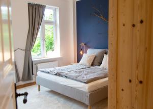 ein Schlafzimmer mit einem Bett und einer blauen Wand in der Unterkunft Bake in Waabs
