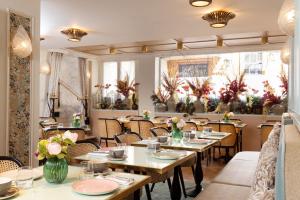 a restaurant with tables and chairs with flowers on them at Lord Byron in Paris +32 photos