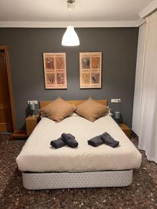 Un dormitorio con una cama grande con dos pares de zapatos. en Playa Malvarrosa House en Valencia
